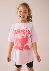 Svetloroza bombažna majica s kratkimi rokavi, z rdečim grafičnim potiskom "Oasis" in napisom "Definitely Maybe" na sprednji strani.