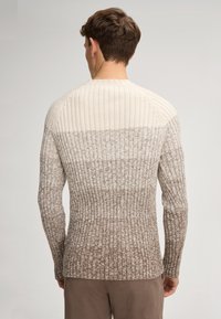 Gerippter Pullover mit einem Gradientendesign, das von Creme an den Schultern zu Braun am Saum übergeht. Hergestellt aus strukturiertem Strickmaterial.