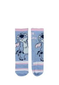 Calzini blu con un personaggio dei cartoni animati, dettagli rosa, un bordo a coste e strisce bianche nella parte inferiore. Il testo stampato recita "Siamo magia."