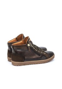 Botas de tobillo de cuero marrón y ante con punta redonda, detalles dorados, cremallera lateral y suela de goma texturizada para mayor tracción.