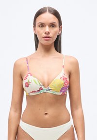 Τοπ μπικίνι με λουλουδάτο μοτίβο σε εκρού απόχρωση, με τριγωνικό σχήμα, λεπτές τιράντες και διακριτικό λογότυπο. Οι λευκές υφασμάτινες βερμούδες συμπληρώνουν το σχέδιο.