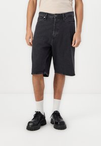 Black denim shorts with a relaxed fit, featuring a button and zipper closure, five pockets, and subtle stitching details.