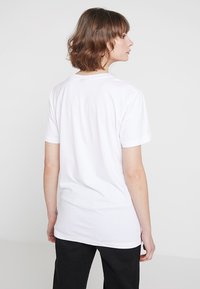 Vit kortärmad t-shirt med rak skärning och mjukt tyg, med en klassisk rund halsringning och utan synliga mönster eller detaljer.