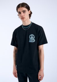 Camiseta de algodón negra con un diseño gráfico en azul claro en la parte frontal, de manga corta y corte relajado.