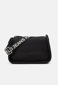 Czarna nylonowa torebka na ramię o prostokątnym kształcie. Posiada wytłoczony napis z marką oraz kontrastowy pasek z napisem "KARL LAGERFELD JEANS".