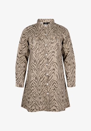 Beżowa sukienka koszulowa w brązowy wzór zebry na całej powierzchni, z zapięciem na guziki z przodu, spiczastym kołnierzykiem oraz dwiema kieszeniami na piersi. Długie rękawy.