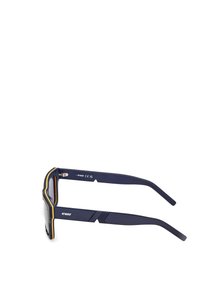 Laivätason aurinkolasit paksulla kehyksellä, joissa on keltaisia yksityiskohtia, kaareva muoto ja teksturoitu temppeeli. Brändäys näkyvissä sivulla.