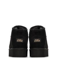 Botas de tobillo negras con un material suave y acolchado, con una suela de goma plana y un pequeño lazo en la parte posterior. Logotipo "Ella" en el lateral.