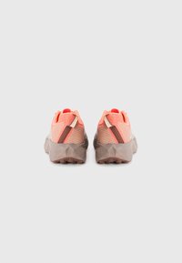 Trail running shoes with a mesh upper in coral and gray, featuring a textured brown sole and a rear pull tab with accents.