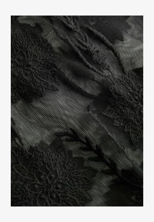 Material negru transparent cu modele mari florale brodate și detalii texturate care creează un design stratificat, delicat.