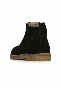 Černé semišové kotníkové boty s texturovanou hnědou gumovou podrážkou, s hladkým vnitřním podšívkou a jemným logem na vnější straně.