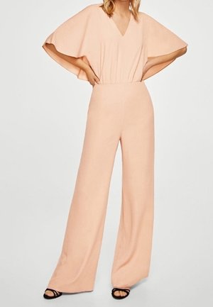 Vaaleanpunainen haalari, jossa on V-aukko, leveät lyhyet hihat ja istuva vyötärö; siinä on leveälahkeiset housut, jotka luovat sulavan siluetin ja pehmeän tekstuurin.