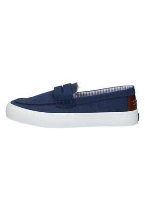 Scarpa slip-on in tela blu navy con suola in gomma bianca. Presenta cuciture decorative e un accento in pelle marrone sul tallone. Interno a righe.