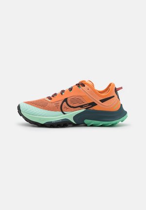 Orange and mint green running shoe with black swoosh logo, textured sole, and multicolored laces, displayed on a white background.