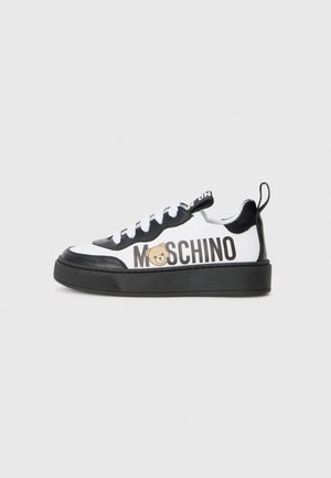 Zapatillas en blanco y negro con suela de goma, diseño con cordones y la marca "Moschino" con un gráfico de oso en el lateral.
