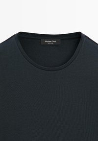 Sort bomuld t-shirt med rund halsudskæring og glat overflade. Har et mærke med teksten "Massimo Dutti" bag på nakken.