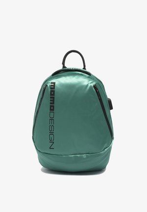 Sac à dos bleu sarcelle avec texte vertical noir "Momo DESIGN", deux poches diagonales zippées et une poignée supérieure noire sur fond blanc.