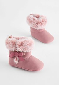 Lyserøde faux suede støvler med en fluffy lyserød pelskant, bånddetalje, rund tå og blød tekstur. Kort design med syede detaljer.