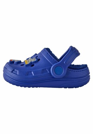 Sabot albastru cu căptușeală pufoasă, orificii circulare de ventilație și personaje decorative pe partea superioară. Dispune de o curea de sprijin rezistentă și o talpă texturată.