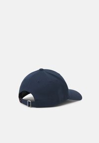 Gorra de béisbol azul marino con visera curvada, tela texturizada, correa ajustable en la parte posterior y diseño estructurado de seis paneles.