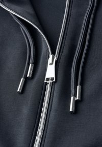 Schwarze Zip-Up-Hoodie mit silbernem Reißverschluss und zwei Ziehschlaufen, glattem Stoff mit Struktur und kontrastierender Innenauskleidung.