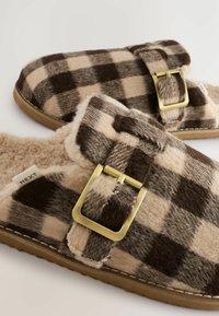 Checkered brown and beige slippers with a fuzzy texture, featuring a gold buckle and soft lining, mounted on a non-slip sole.