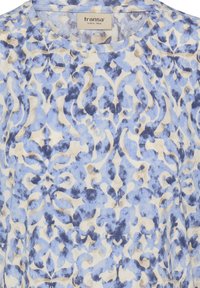 Lyseblåt mønstret stof med indviklede blomster- og abstrakte motiver i mørkere blå og cremefarver. Blød tekstur med et afslappet snit.