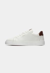 Adidași din piele albă cu vârful rotunjit, sistem de închidere cu șireturi în față și un accent din piele maro pe toc. Au o talpă texturată și un branding subtil.
