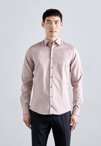 Lichtroze langemouwen overhemd met een knoopsluiting aan de voorkant en slim fit. Gladde stof, puntige kraag en zilveren knopen. Gestyled met donkere broeken.
