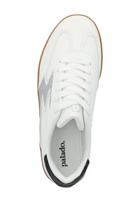 Sneaker bianca in pelle con un design zigzag metallico grigio, con lacci tondi, un tallone nero e una suola in gomma marrone.