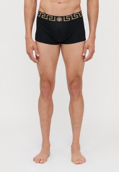 Boxer brevi neri con un motivo a chiave greca dorata lungo l'elastico in vita, realizzati in un tessuto morbido e elastico per il massimo comfort.
