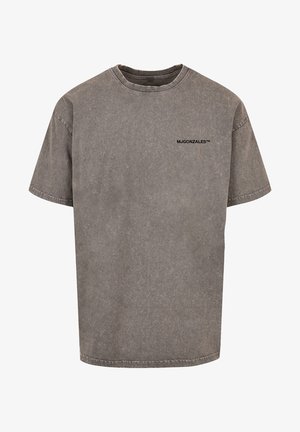 Pilkas per didelis t-shirt, pagamintas iš medvilnės su nusidėvėjusiu efektu. Yra apvalus iškirpimas ir mažas juodas logotipas ant krūtinės.