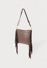 Barna bőr táska, az egyik oldalon rojtos díszítéssel. Cipzáras záródással és állítható vállpánttal rendelkezik, aranyszínű fém díszítésekkel.