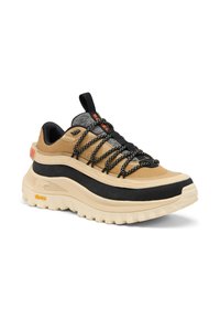 Harmaa ja musta sneakeri, jossa on paksu pohja, teksturoitu yläosa, heijastavat nauhat ja harmaa kangasosio, jossa on Vibram-logo.