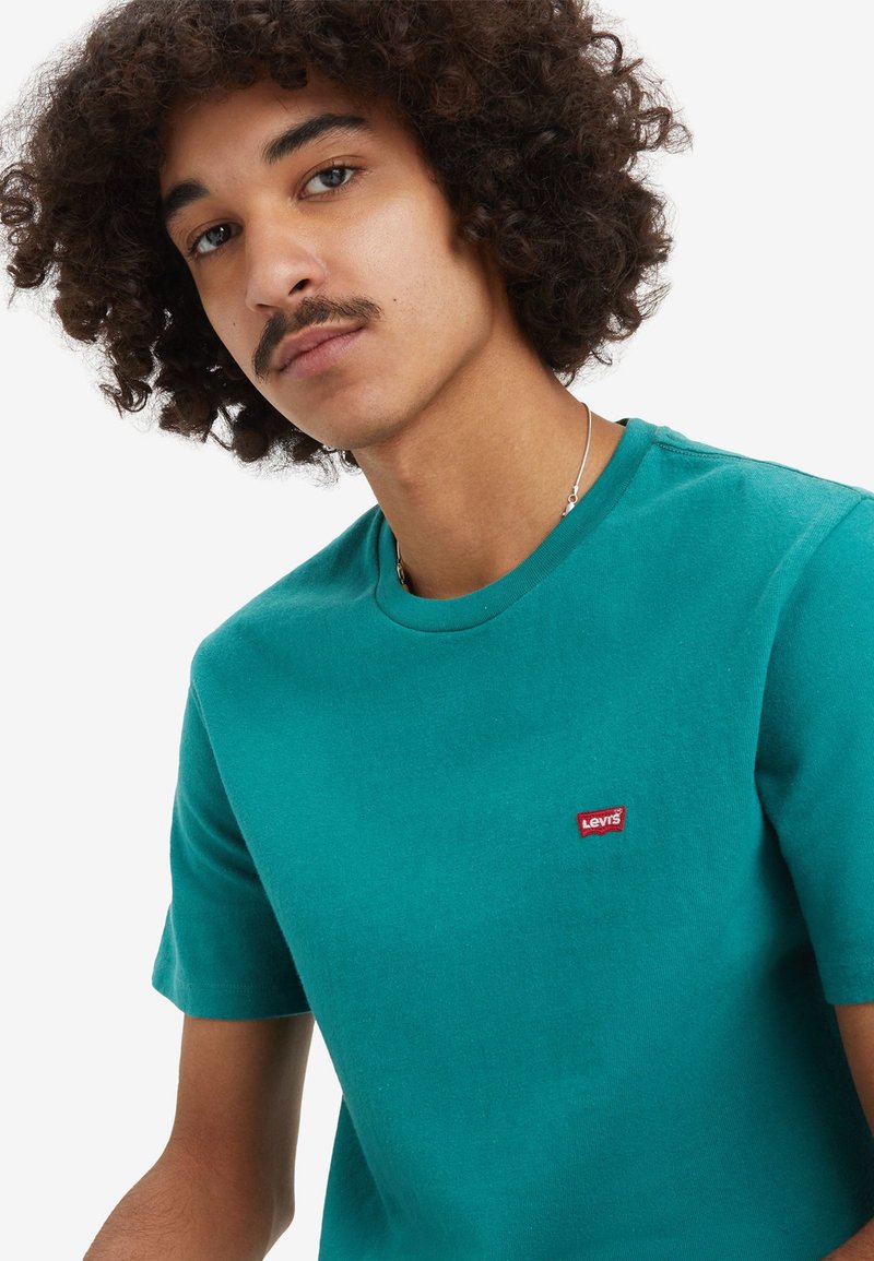 Türkises Rundhalsshirt aus Baumwolle mit kurzen Ärmeln und einem kleinen roten Levi's-Logo auf der linken Brustseite.