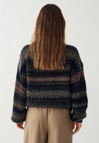 Pletený sveter s textúrovaným, viacfarebným vzorom v tmavých odtieňoch modrej a hnedé, s voľným strihom a dlhými rukávmi.