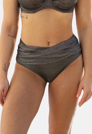 Frau trägt einen metallisch grauen Bikini mit hohem Bund und passendem Oberteil, zeigt Tattoos auf den Armen und einen Bauchnabelpiercing.