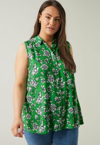 Blusa verde senza maniche con motivo floreale in bianco e nero, dotata di colletto e vestibilità rilassata, realizzata in tessuto leggero.