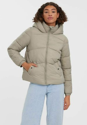 Olijfgroene gewatteerde jack met een capuchon, rits aan de voorkant en zijzakken. Heeft een geborduurd patroon en elastische manchetten. Gemaakt in combinatie met lichtblauwe jeans.