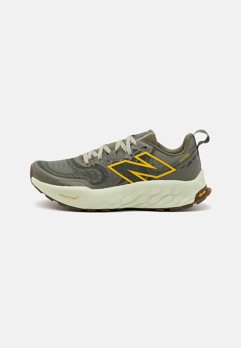 Baskets New Balance gris et jaune avec lacets blancs, semelle épaisse et rembourrée, et languette au talon, vues de profil sur fond blanc.