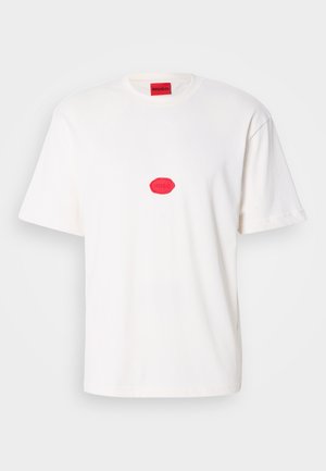 Witte katoenen t-shirt met korte mouwen, met een rood logo patch in het midden en een rood label op de hals. Casual ontwerp.
