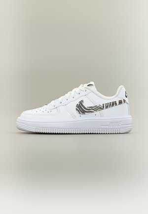 Biela teniska Nike Air Force 1 s čierno-bielym zebrovým vzorom loga Swoosh a bielou podrážkou na svetlom neutrálnom pozadí.