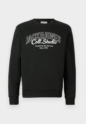 Svart sweatshirt med långa ärmar och ribbad mudd. Har stor vit text: "JACK&JONES Coll. Studio" och ytterligare detaljer nedan.