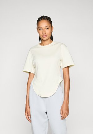 Light beige short-sleeve t-shirt featuring a round neck and curved hemline. Smooth cotton material with a relaxed fit.