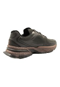 Black athletic shoe featuring a textured upper, padded collar, and a brown speckled sole with a layered design for enhanced cushioning.
