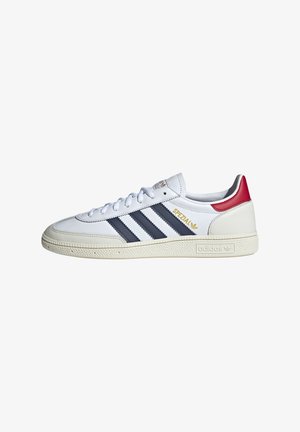 Baskets Adidas Spezial blanches avec des bandes noires, un onglet de talon rouge, des inscriptions dorées et une semelle texturée blanc cassé, vues de profil.