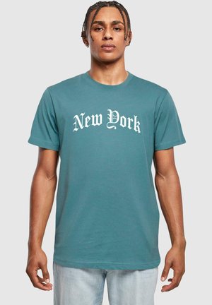 Teal bomulds t-shirt med "New York" i hvid gotisk skrift. Korte ærmer og en afslappet pasform med en glat tekstur.
