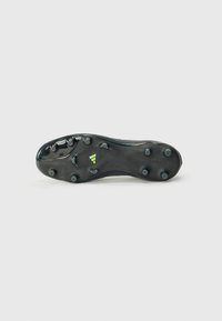 Black football cleat with a textured, flexible sole, featuring six conical studs and a green accent near the heel, labeled "COPA."