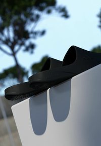 Black rubber slides with a smooth finish, featuring a contoured design and textured sole. "LIGHTSTRIKE" embossed on the side.