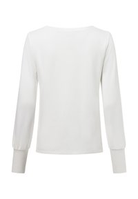 Long-sleeve white top with a round neck, smooth texture, and puffed sleeves. The design features fitted cuffs and a relaxed silhouette.